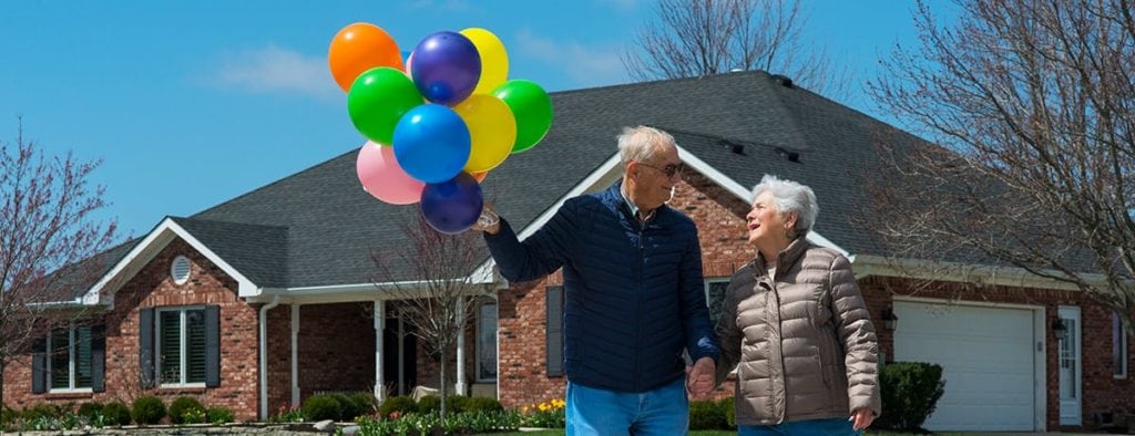 senior couple in front of home