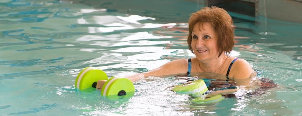 senior woman exercising in a pool at otterbein