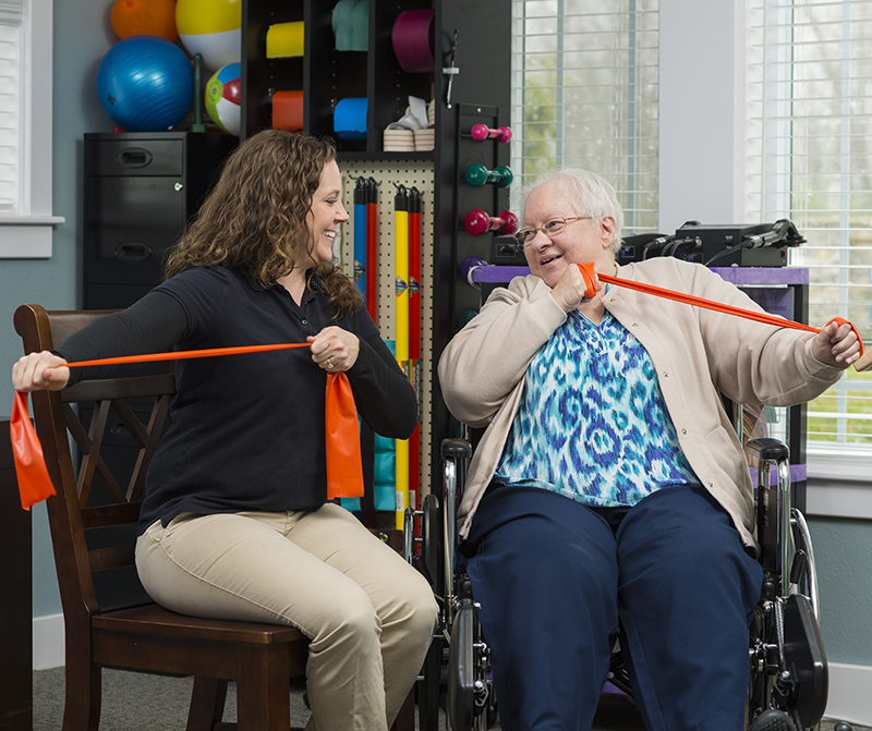 Resident and therapist working with stretch bands