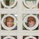 Residents being silly looking at each other through decorative wall