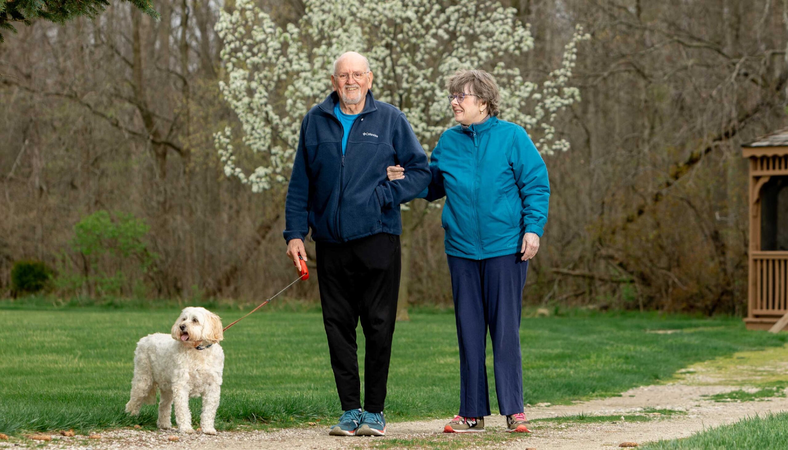 a man and a woman on a walk with their dog