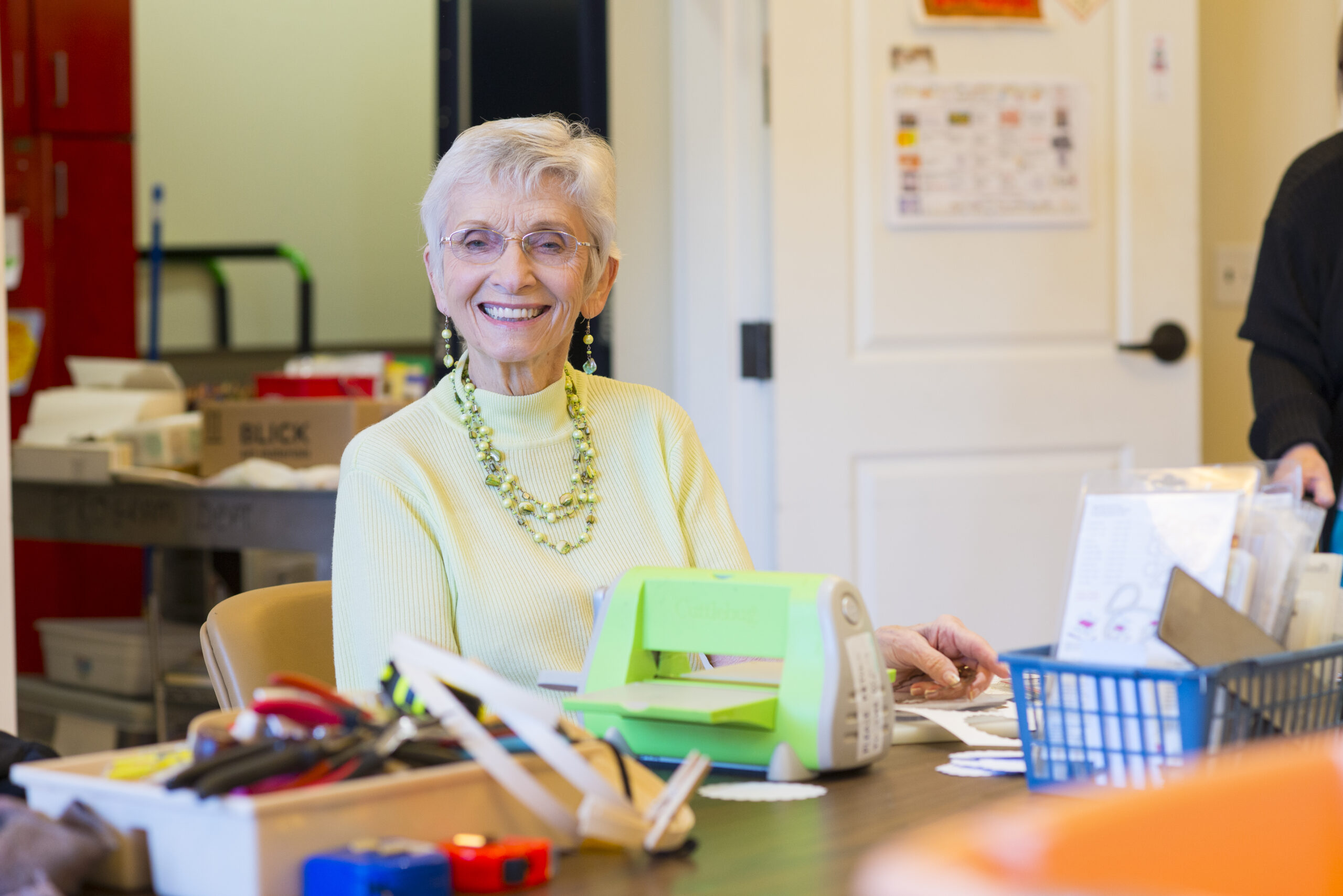 A woman sitting at a table doing arts and crafts