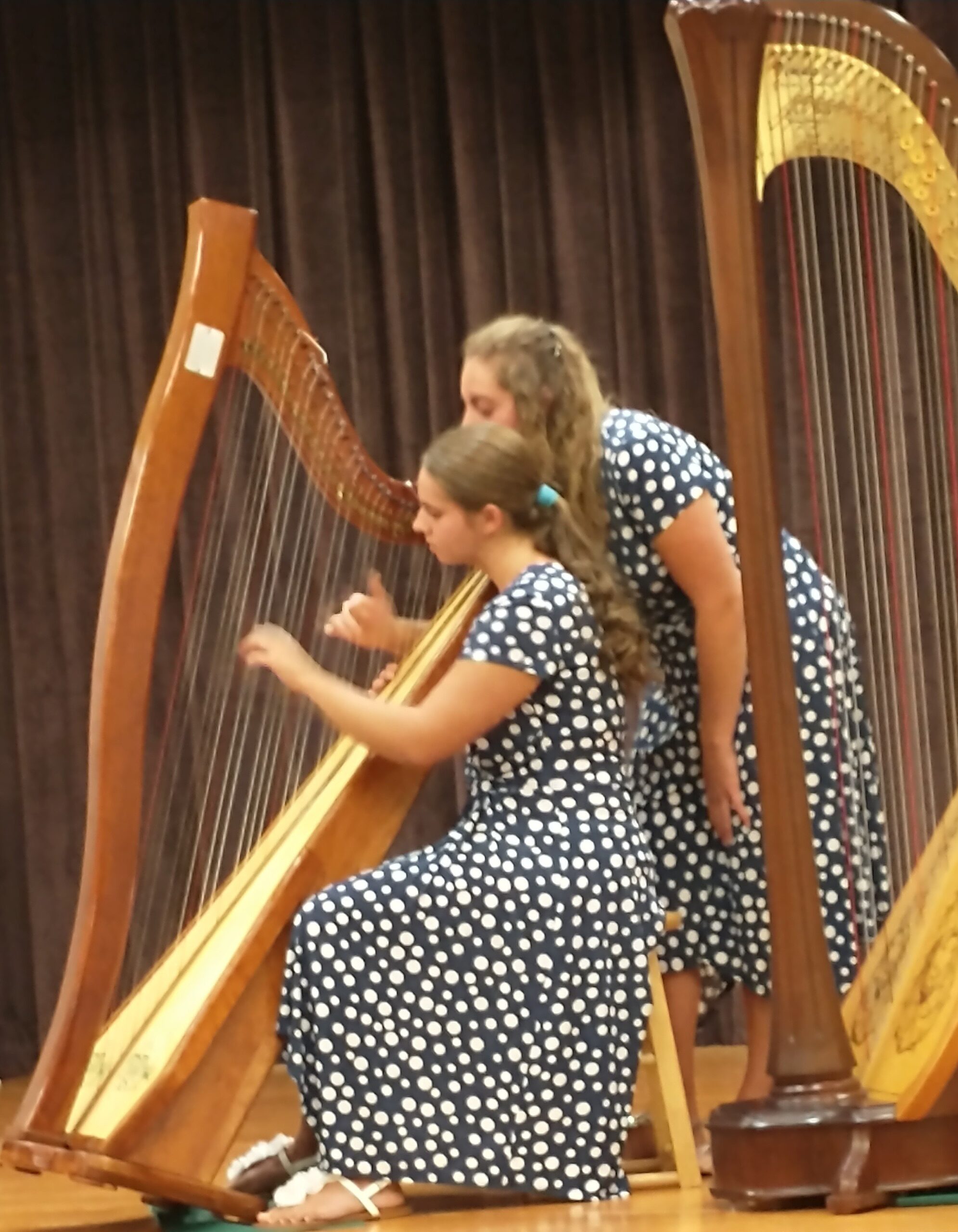 Claggett sisters playing a harp together