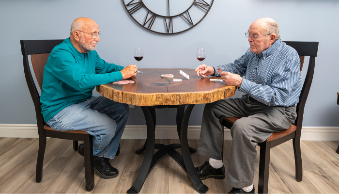 Carl and another gentleman resident playing cards and enjoying a glass of wine. 