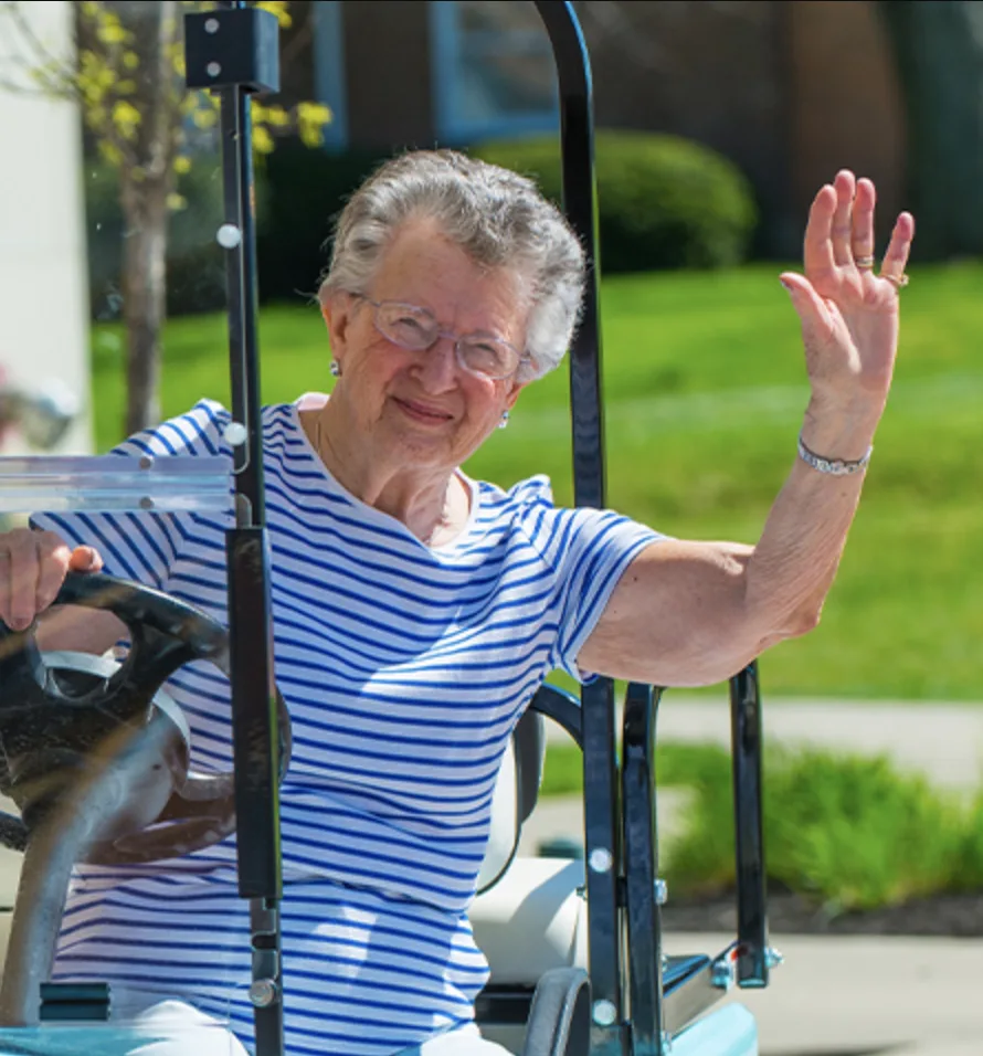 Otterbein resident waving from a golf cart