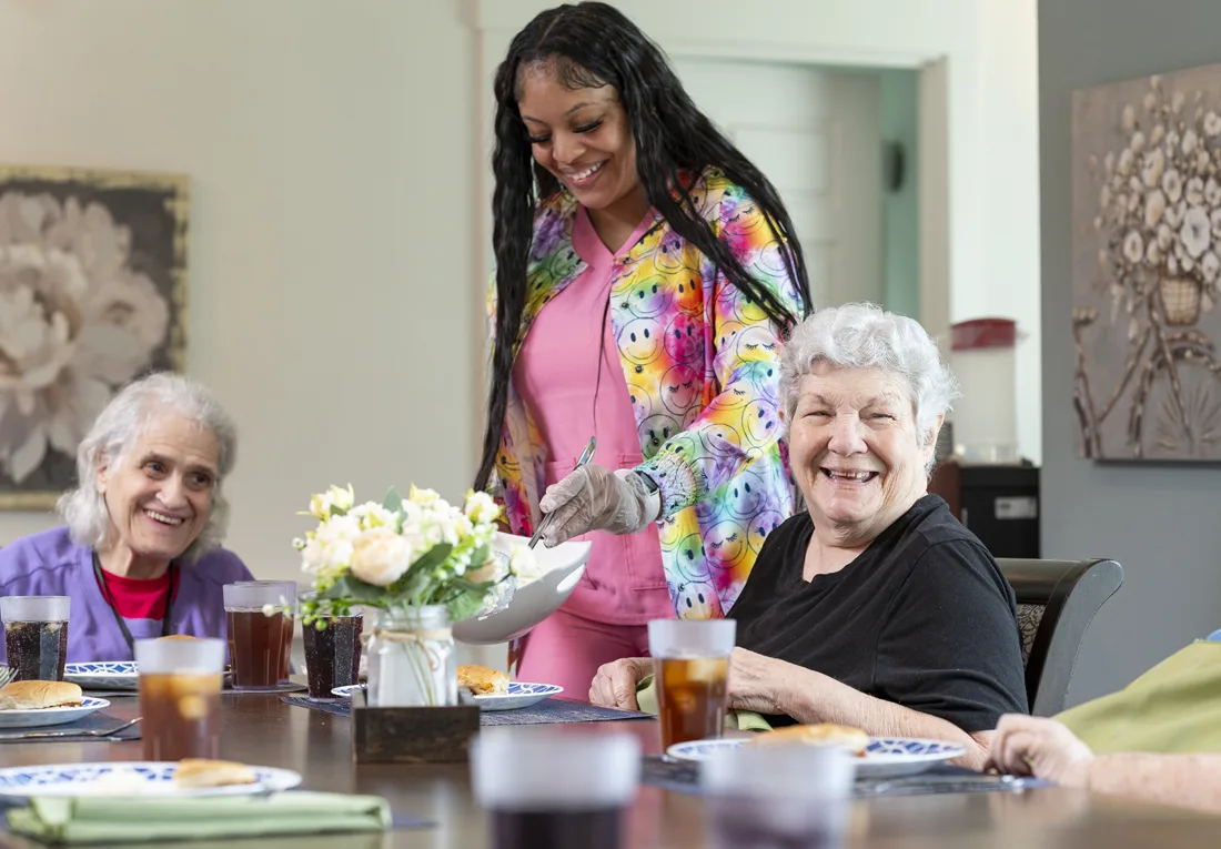 Otterbein elder assistant serves Otterbein small house elders at the table