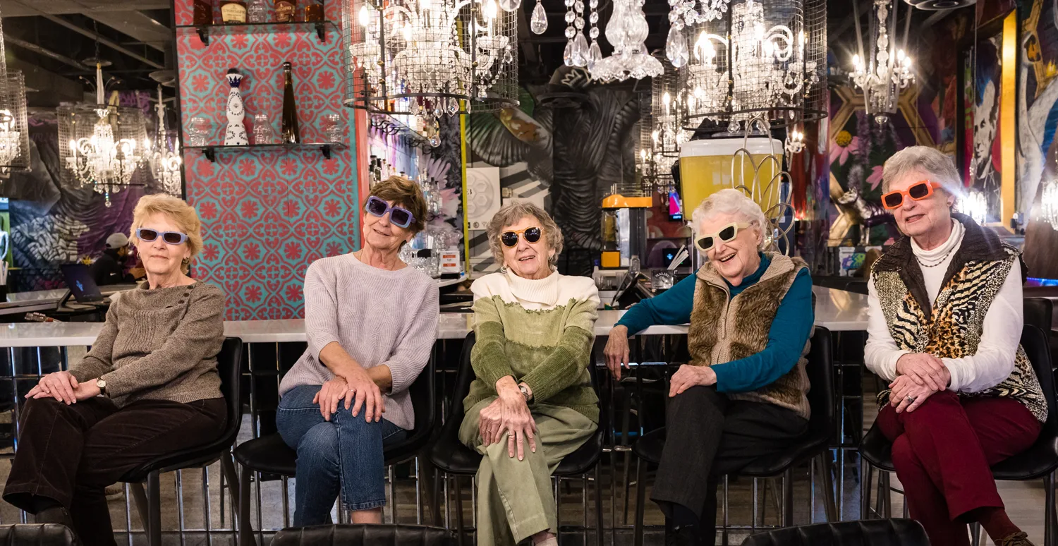 Otterbein Pemberville residents sitting on stools and wearing sunglasses while on an outing