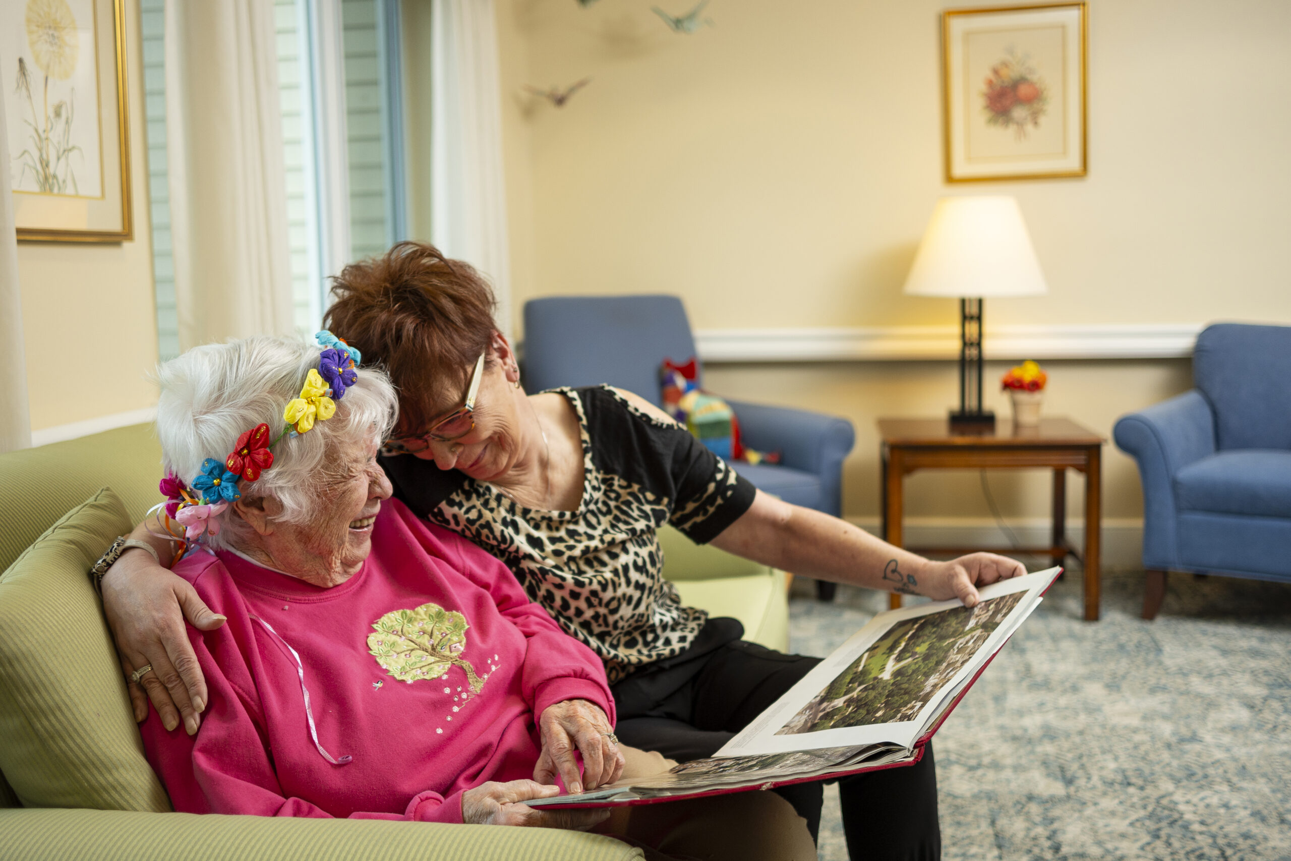 Two senior women smile and spend time together in assisted living
