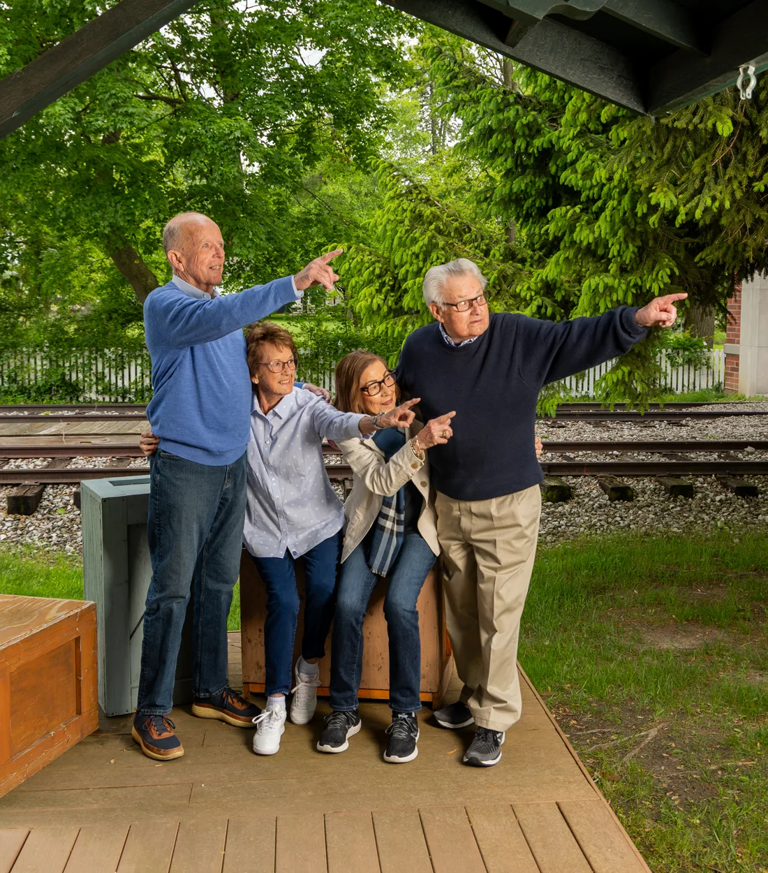 Otterbein Sunset Village residents pointing toward something in the distance while in front of railroad tracks