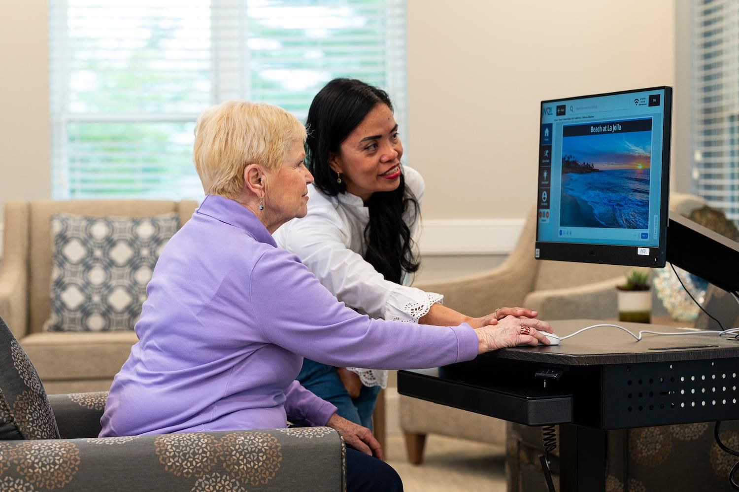 Otterbein resident views images on a computer with a partner assisting her