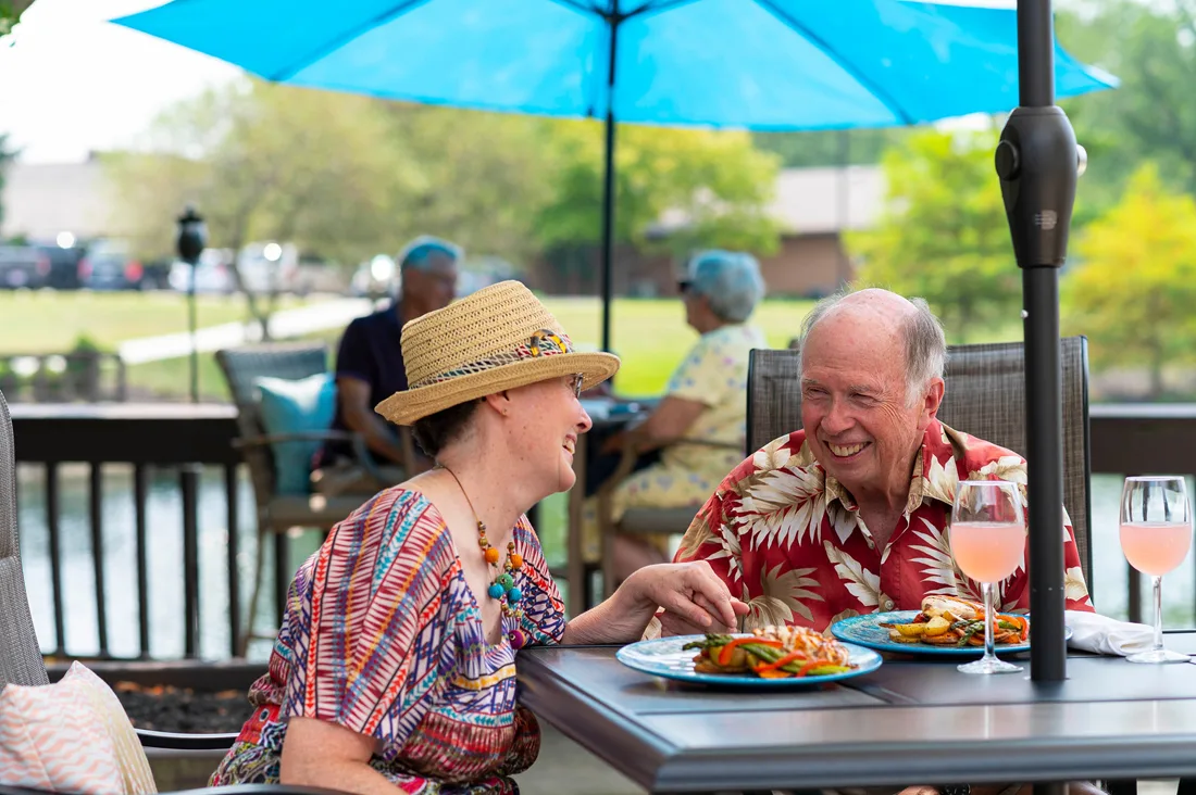 Residents dine outdoors sharing food, drinks, and conversation