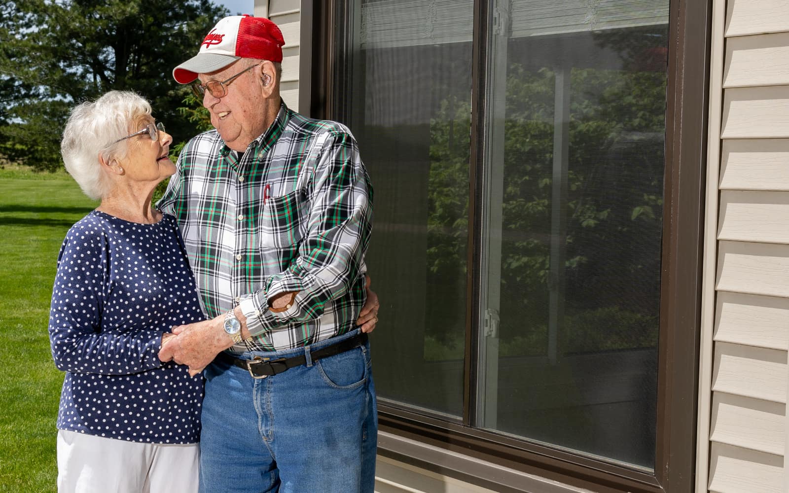 Independent Living couple embracing outside their home